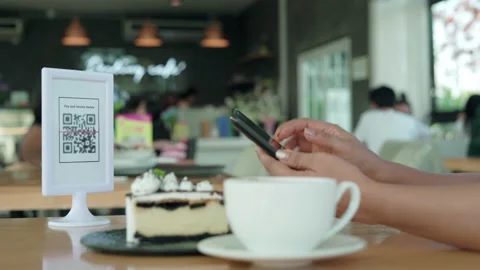Pay online scan QR code.Women using their phones for scanning to pay for coff Stock Footage 164388032