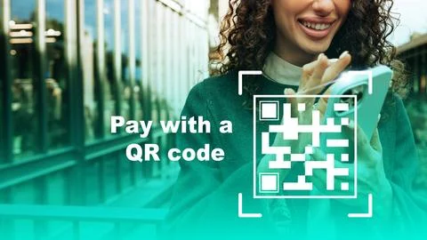 Pay with a QR code using a smartphone outdoors in a busy area with a focus on Foto stock