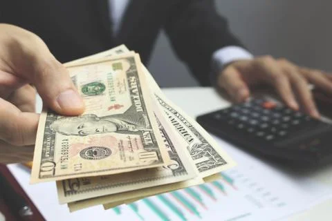 Pay the US dollar , Hand use dollar money on the office desk  investment and  Stock Photos