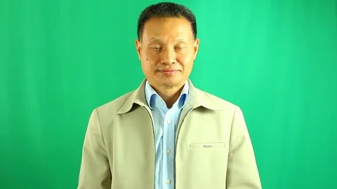 Paying respect man with green background,  in studio Chiangmai Thailand Stock Footage 113308835