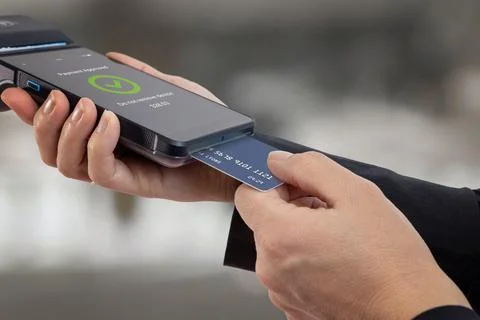 Payment card being processed by portable POS terminal with confirmation scr.. Stock Photos