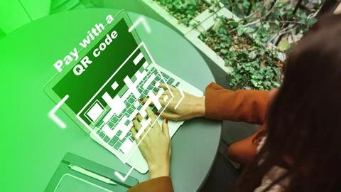 Payment via QR code on a laptop at an outdoor table during the day Stock Photos