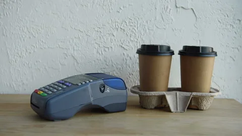 Payment terminal and disposable cups on wooden surface Stock-Footage 133779643