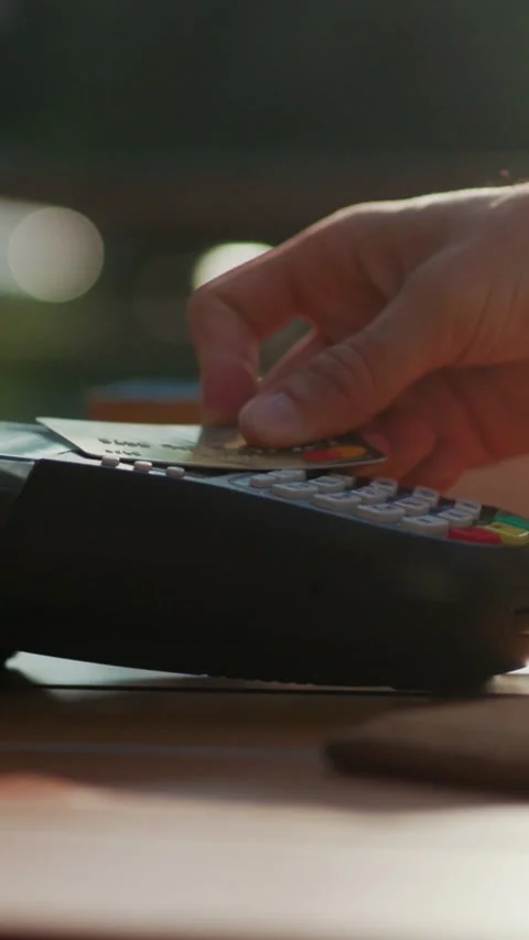 A Payment Terminal is placed on a Wooden Table in a bustling Restaurant setting Stock Footage 314959818