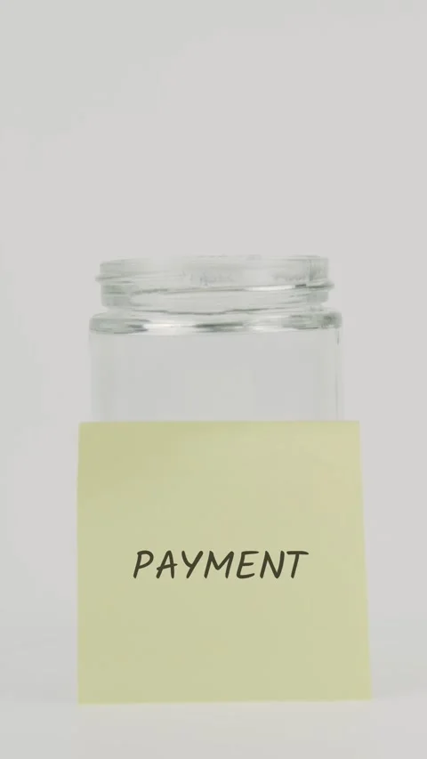 Payment text or word on yellow sticky note attached to glass jar with hand Vídeo Stock 311764956