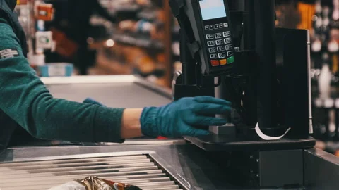 Payment through the Terminal in the Store. Cashier in Gloves with the Terminal Stock Footage 144406571