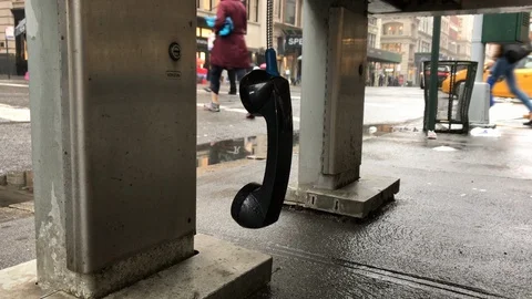 Payphone receiver dangling public pay phone raining Manhattan rain New York City 動画素材 105985233
