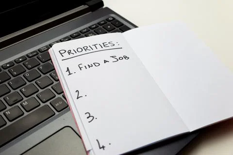 Pc and notebook with text "priorities, find a job".  Stock Photos