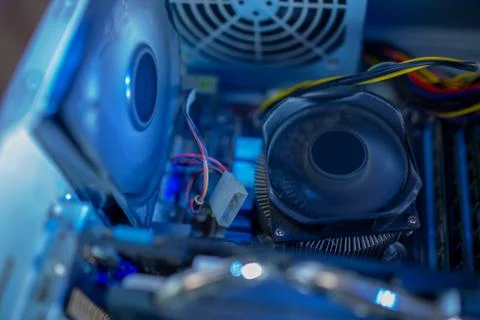 PC components in dust. The chassis cooling fan and the CPU fan are working Stock Photos