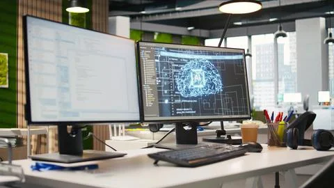 PC in empty IT startup office displaying artificial intelligence code Stock Photos