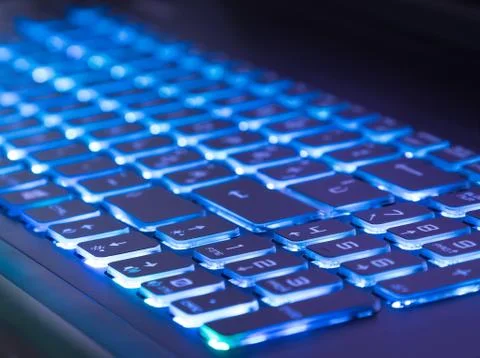 Pc keyboard with blue light tint, close-up view Foto stock