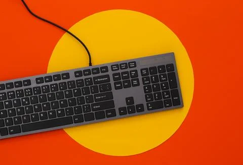 PC keyboard on orange background with yellow circle. Top view Stock Photos