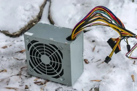 The PC power supply lies at an electronics dump in winter in the snow Stock Photos