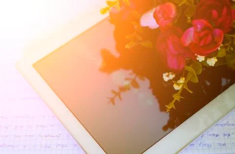 A PC tablet with a bouquet of flowers on the table. Happy Teacher's Day. Clas Stock Photos