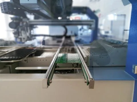PCB assembly first stages. PCB on the rails of production line inside pick an Foto stock