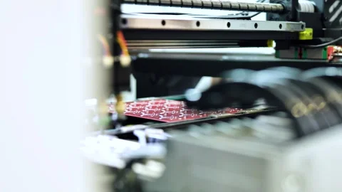 PCB manufacturing machine assembling electronic components on red circuit board Stock Footage 323379956