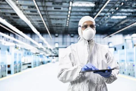 PCB systems architect walking in microchip factory, designing silicon wafers Stock Photos