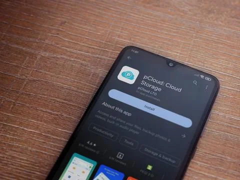 PCloud app play store page on smartphone on wooden background Stock Photos