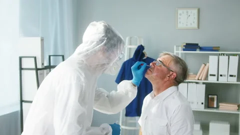 PCR test process, Doctor wearing protective equipment taking sample from nose of Stock Footage 157825761