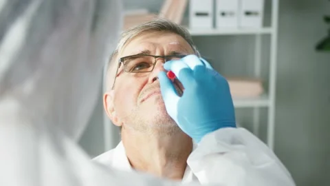 PCR test process, Doctor wearing protective equipment taking sample from nose of Stock Footage 157825861