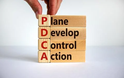 PDCA, plan develop control action symbol. Wooden blocks with words 'PDCA, pla Stock Photos