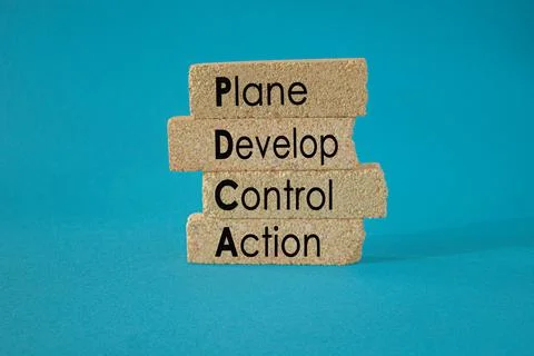 PDCA, plan develop control action symbol. Brick blocks with words PDCA Stock Photos