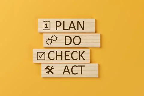 PDCA, plan - do - check - act, schema on wooden blocks over orange background Illustrazione stock