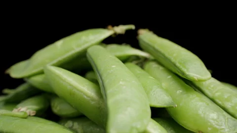 Pea Pods close-up stacked on top of each other, rotating on a black background. Stock Footage 277166725