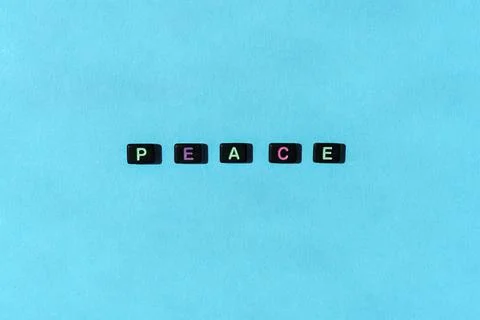 Peace button concept. Black beads on blue background making word Stock Photos