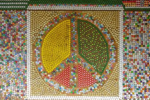 Peace sign made of thousands of tiny colorful bottle tops . peaceful wall art Foto stock