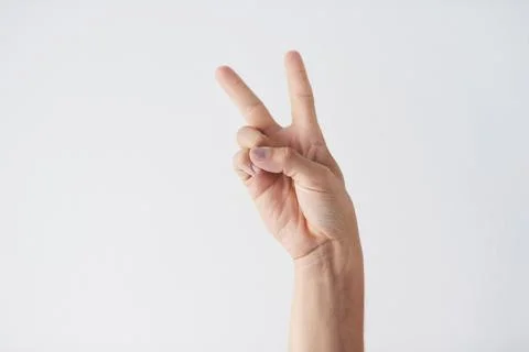 Peace to the world. a unrecognizable persons hands against a grey background Stock Photos
