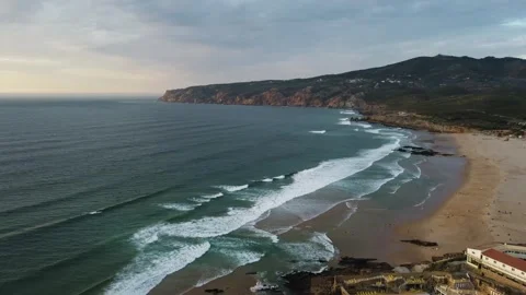 Peaceful aerial perspective capturing gentle waves meeting sandy shore near Stock Footage 345499822