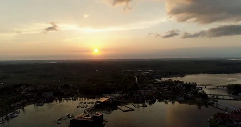 Peaceful aerial shot of sunset over port town next to lake Stock Footage
