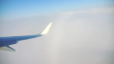 A peaceful airplane wing floating through misty clouds in 4K slow motion 60fp Stock Footage 286710770