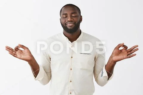 Peaceful and delighted African-american bearded male feeling nirvana smiling Stock Photos