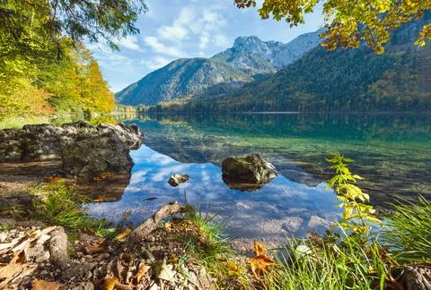 Peaceful autumn Alps mountain lake with clear transparent water and reflectio Stock Photos