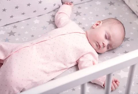 Peaceful baby lying on a bed while sleeping, top view Stock Photos
