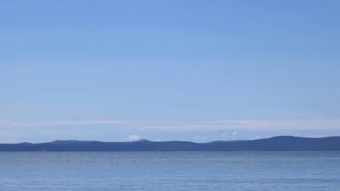 Peaceful blue sky over distant dark mountain horizon in video Stock Footage 337415146