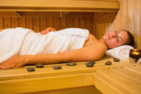 Peaceful brunette woman lying in a sauna Stock Photos