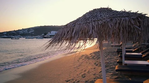 Peaceful empty beach with straw umbrellas in the evening. Stock Footage 94837032