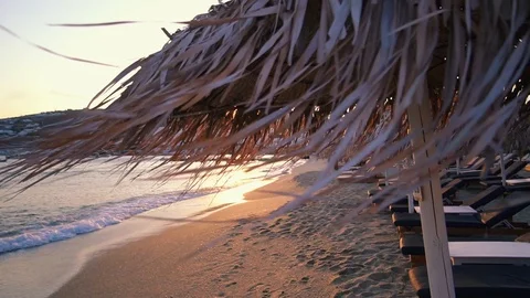 Peaceful empty beach with straw umbrellas in the evening. Stock Footage 95833184