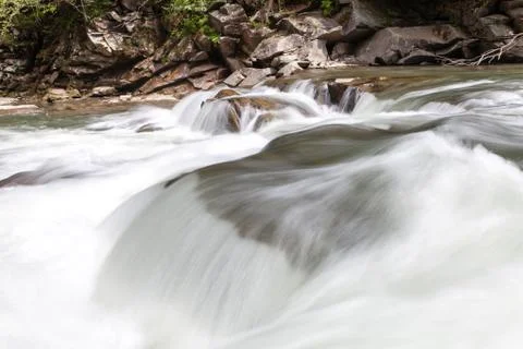 Peaceful flowing stream in mountains Stock Photos