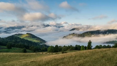 Peaceful foggy morning with clouds moving over countryside mountains. Time lapse Stock Footage