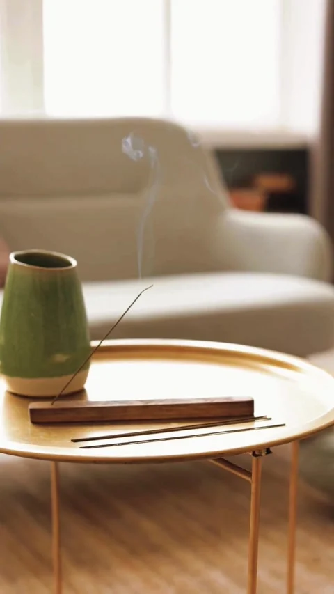 A peaceful incense stick burning in a modern home living room setting. Video stock 342675329