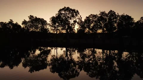 Peaceful lake with calming reflection of trees. Aerial shot, golden hour sunset Stock Footage 198343031