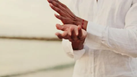 Peaceful Man Practices Graceful Hand Movements by the Sea Stock Footage 310016633