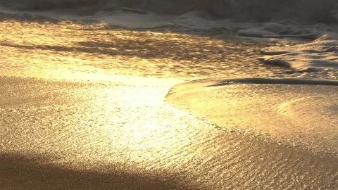 Peaceful ocean surf at sunset on a soft sandy shore with glowing warm light. Stock-Footage 331488164