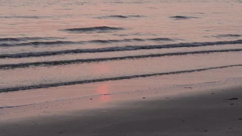 Peaceful ocean surf at sunset on a soft sandy shore with glowing warm light. 库存影片 331488329