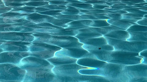 Peaceful oscillating aqua blue pool water with sun reflections Stock Footage 285419941