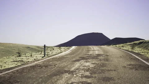 Peaceful pathway ascends through desolate terrain beneath soft sky Stock Footage 329944262